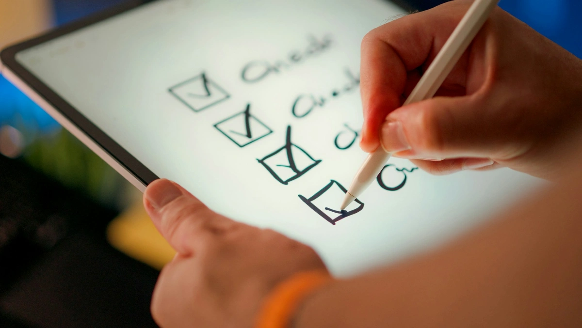 Rekryteringstest - hand som fyller i checkboxar på surfplatta